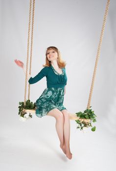 beautiful woman in a green dress on a swing