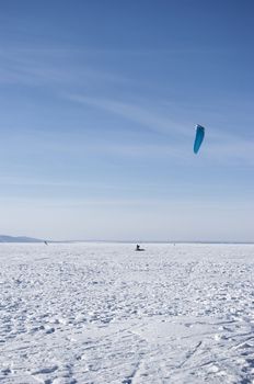 Winter kite skiing on the frozen river