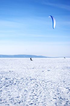 Winter kite skiing on the frozen river