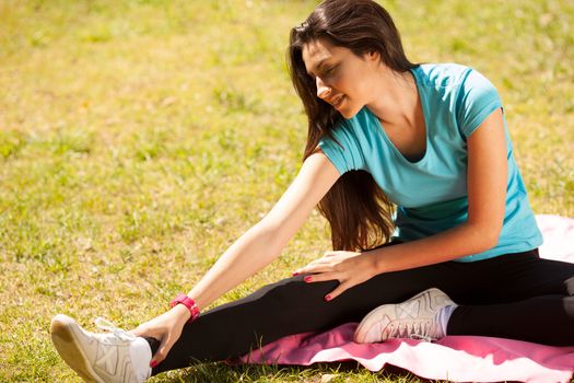 young beautiful woman stretching after sport outdoors