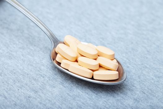 Pills on a metal spoon. Close-up photo