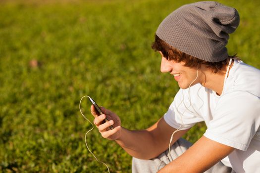 young handsome man consulting phone outdoors