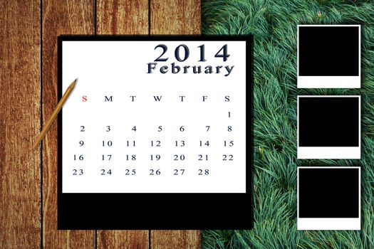 Calendar 2014 set with photo frame on wooden floor and grass background