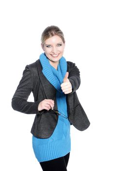Casual young blonde woman dressed in blue giving the thumbs up sign isolated on white