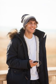 young handsome man consulting phone outdoors