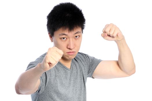 Young Asian man in fighting position, on white
