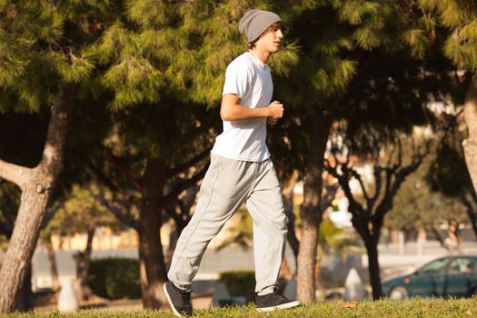 young handsome man jogging in public park