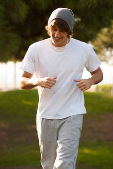 young handsome man jogging in public park