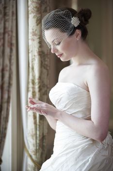 pretty bride in wedding dress looking at her wedding ring