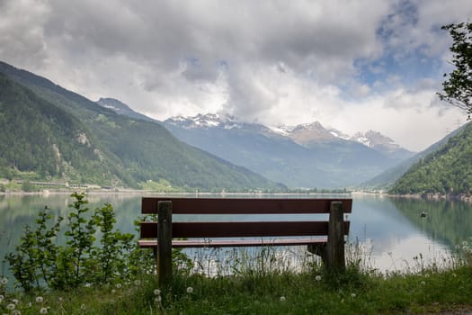bench in the high mountains at the lake Poschiavo, Switzerland Alps
