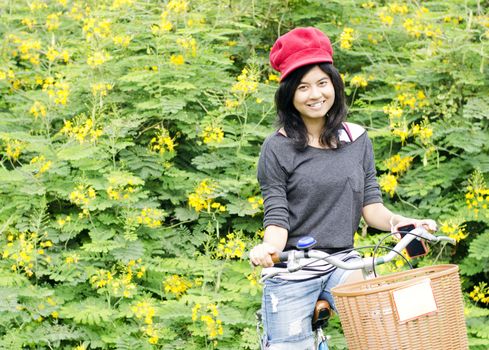 Portrait of an happy smiling girl riding a bicycle in the park.Looking at camera. 