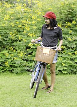 Young woman with retro bicycle in a park - outdoor portrait 