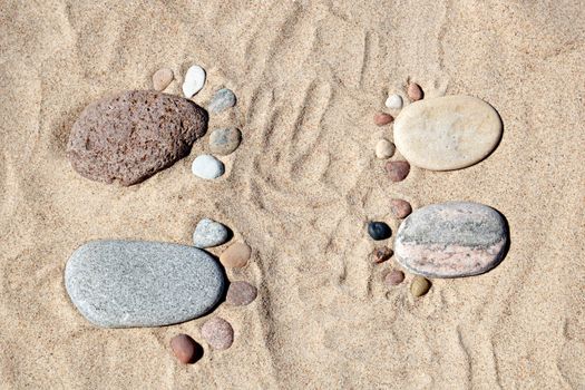 feet made from stone on the beach sand