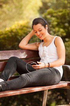 young latin woman using celphone outdoors