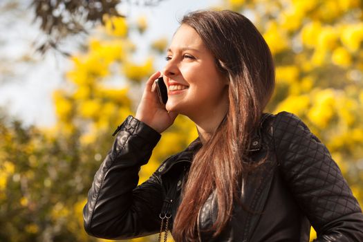 young latin woman using celphone outdoors