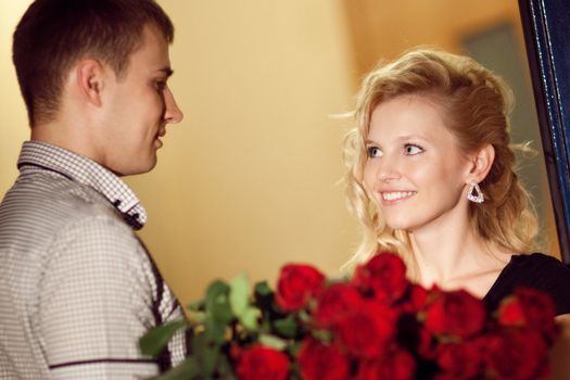 man gives red roses to a girl