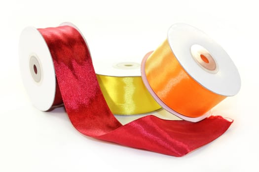 three rolls of ribbon in front of white background