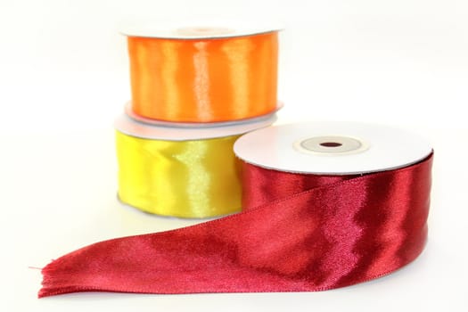 three rolls of ribbon in front of white background