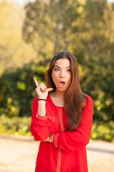 young beautiful woman makes funny face in red shirt