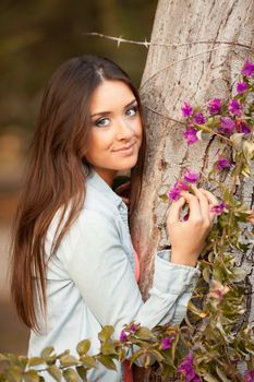 young beautiful teen woman smells flowers