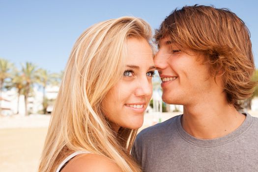 Young beautiful couple closeup portrait at the beach on sunny day