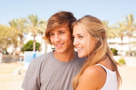 Young beautiful couple closeup portrait at the beach on sunny day