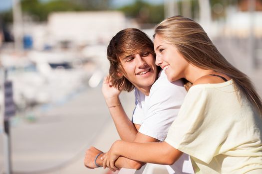 Young beautiful couple enjoying a walk by the harbour