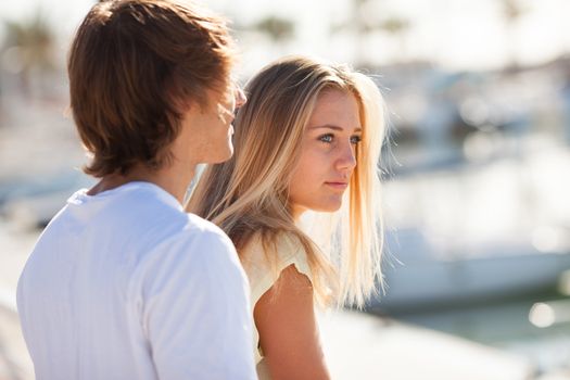 Young beautiful couple enjoying a walk by the harbour