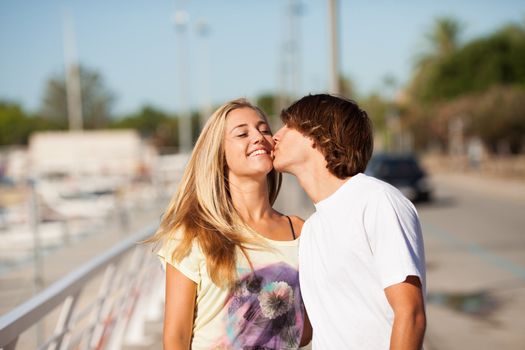 Young beautiful couple enjoying a walk by the harbour