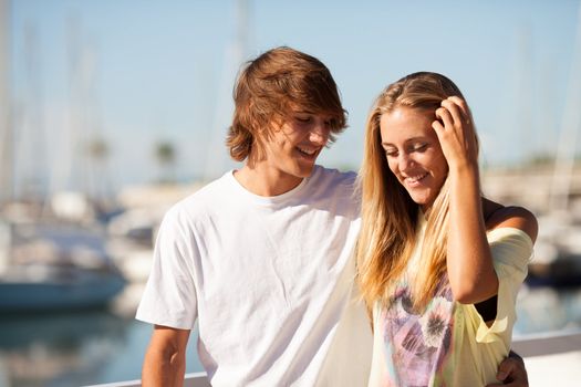 Young beautiful couple enjoying a walk by the harbour