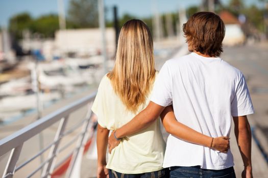 Young beautiful couple enjoying a walk by the harbour