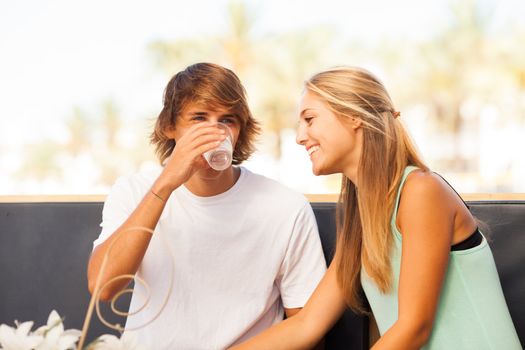 Young beautiful couple having fun in a beach bar