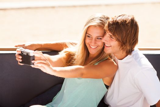 Young beautiful couple taking selfportrait with an old camera