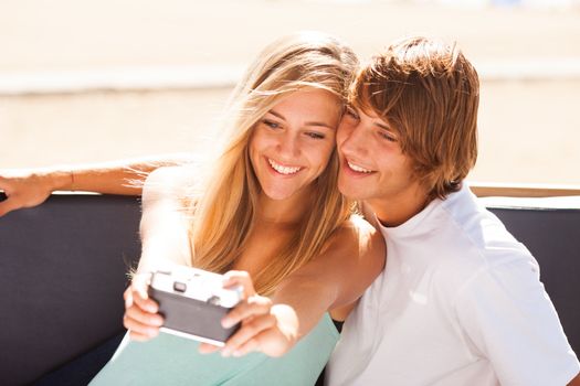 Young beautiful couple taking selfportrait with an old camera