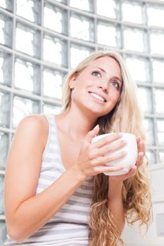 young beautiful woman drinks coffee on white cup