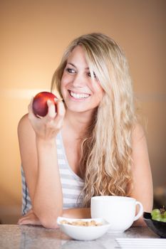 Young beautiful woman having a healthy breakfast in the kitchen