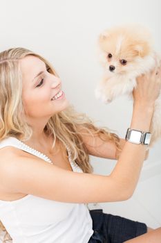 young woman playing with her tinny dog at home