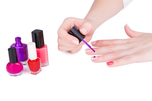 Young woman paint her nails. On white.