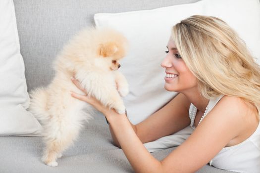 young woman playing with her tinny dog at home