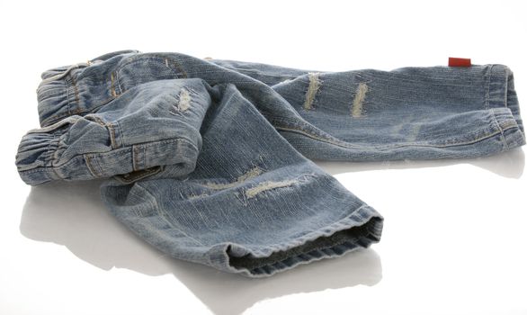 infant or baby denim jeans in a pile with reflection on white background