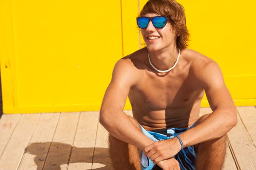 handsome man watching the sea on a lifeguard house