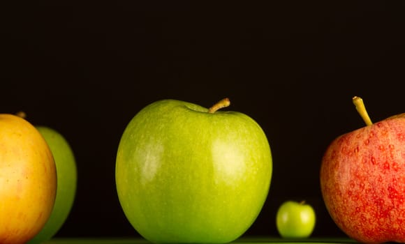 Apples in a row on black backround