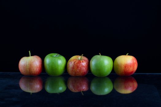 Apples in a row on black backround