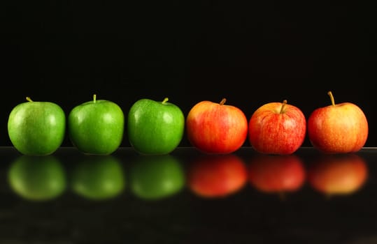 Apples in a row on black backround