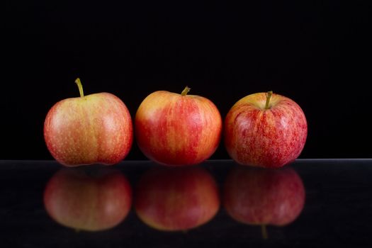 Apples in a row on black backround