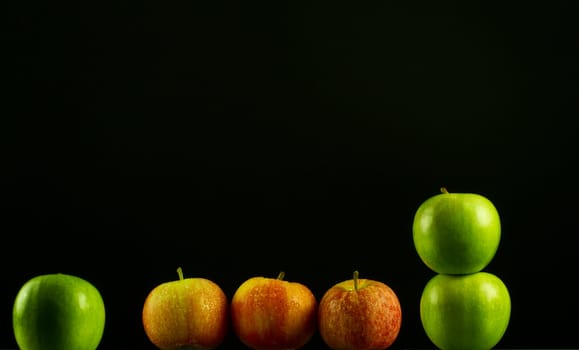 Apples in a row on black backround