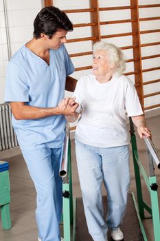 Happy senior woman on walking track looking at physical therapist