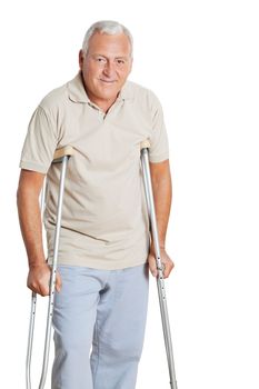 Portrait of happy senior man on crutches isolated over white background.