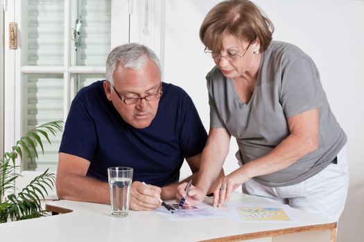 Portrait of mature couple playing scrabble game.