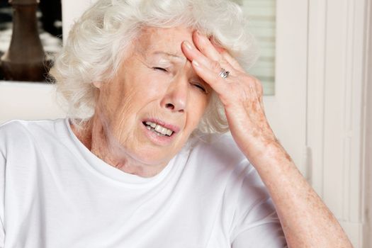 Senior woman with eyes closed suffering from headache